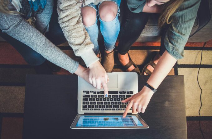 Tre persone attorno ad un computer ad indicare le comunità online