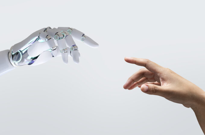 Una mano di un robot e una di un umano che quasi si toccano