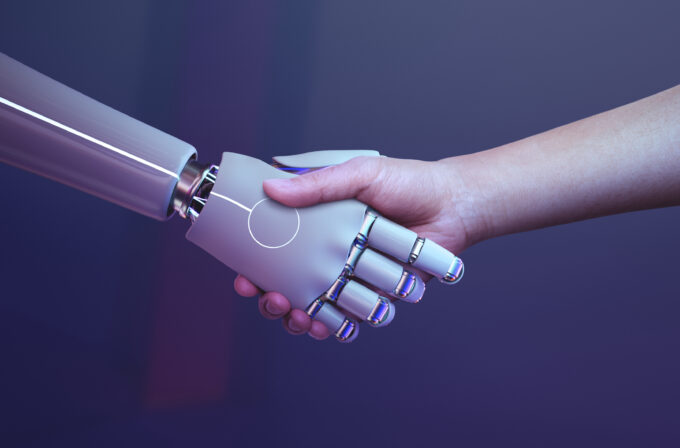 Una mano umana e una robotizzata che si incontrano. Google e ChatGPT